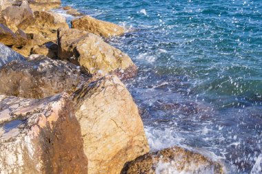 Atina gezinti güvertesinde gün batımının ışınlarında dalgalanan dalgalarla kayalık deniz kıyısı