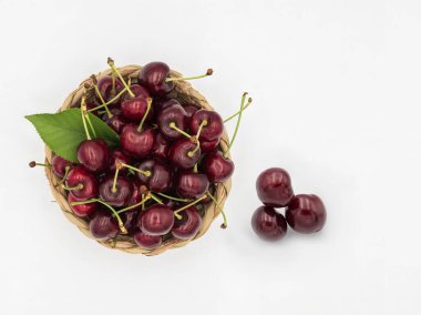 Beyaza izole edilmiş sepetteki lezzetli kirazlar..