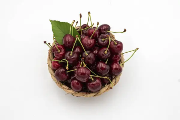 Beyaza izole edilmiş sepetteki lezzetli kirazlar..