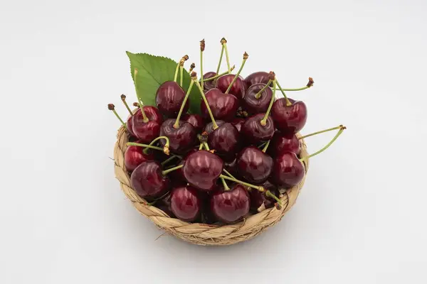 Beyaza izole edilmiş sepetteki lezzetli kirazlar..