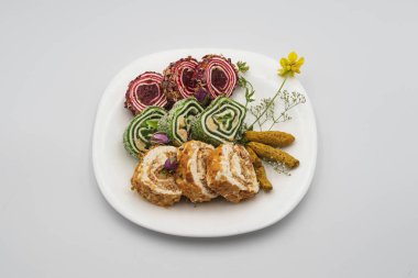 Şam fıstıklı, kaju fıstıklı, seramik tabakta gül yapraklarıyla süslenmiş çeşitli tatlı rulo Raf Lokum. Geleneksel Türk tatlıları.