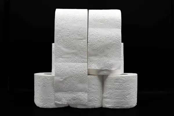 Siyah arka planda kabartmalı desenli birden fazla tuvalet kağıdı rulosu. Hijyen ve Tedarik Konsepti