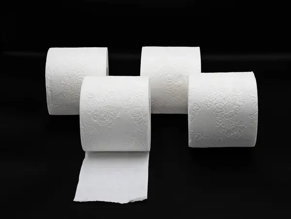 Siyah arka planda kabartmalı desenli birden fazla tuvalet kağıdı rulosu. Hijyen ve Tedarik Konsepti