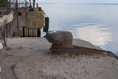 Su üzerindeki paslı eski iskele, doğal manzara ve bulutlu gökyüzü.