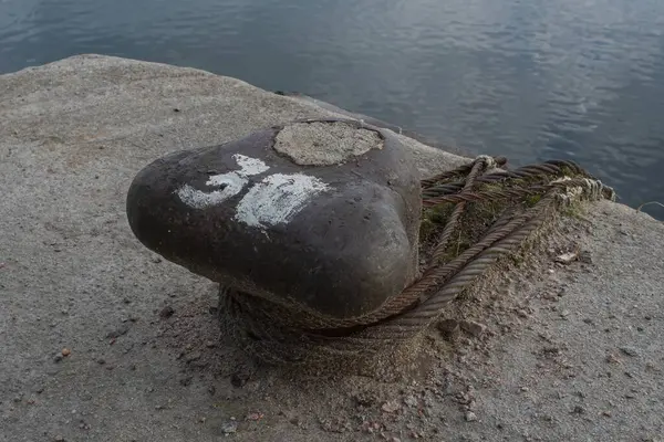 Beton iskelede paslı halatlarla demirlemiş denizcilere yakın çekim.