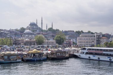 İstanbul, Türkiye 'nin günbatımı manzaralı manzarasında Süleyman Camii, Boğaz kıyısı ve tekneler yer alıyor. Şehrin tarihi siluetini altın gece ışığıyla yakalıyorum.. 