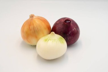 Üç tip soğan ampulünün (kırmızı, sarı ve beyaz) stüdyo görüntüsü beyaz zemin üzerinde sıralanmıştır. Tarım, aşçılık veya sağlıkla ilgili konular için mükemmel.