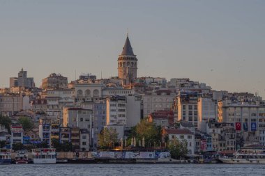 İstanbul 'un renkli şehir binaları ve Boğaziçi rıhtımının üzerindeki Galata Kulesi' nin güzel manzarası. Günbatımında Türk mimarisi ve mirası. Seyahat konsepti ve kültürel hedef. İstanbul 20 Mayıs 2025