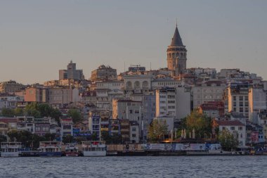 İstanbul 'un renkli şehir binaları ve Boğaziçi rıhtımının üzerindeki Galata Kulesi' nin güzel manzarası. Günbatımında Türk mimarisi ve mirası. Seyahat konsepti ve kültürel hedef. İstanbul 20 Mayıs 2025