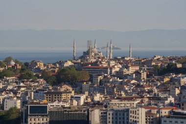 20 Mayıs 2025 'te Sultan Ahmed Camii' nin (Mavi Cami) ve İstanbul 'un geleneksel çatılarının yüksek açılı görüntüsü. Deniz ufku ve yumuşak akşam ışığında cami kuleleri olan kıyı silueti..