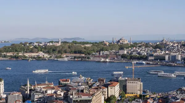 İstanbul 'un Galata Kulesi' nden görünüşü: Boğaz 'ı geçen gemiler ve arka planda Ayasofya ve Topkapı Sarayı da dahil olmak üzere tarihi mimari. Türkiye 'nin kültürel başkentinin şehir ve deniz güzelliği. İstanbul 20 Mayıs 2025