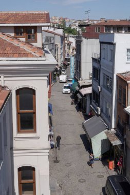 İstanbul 'un tarihi merkezinde, insanlar, eski evler ve kiremitli çatıları olan geleneksel cadde. Güneşli bir günde kentsel mimari ve otantik Türk kenti yaşam tarzı.