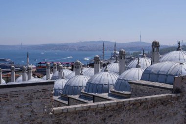 Güneşli bir günde Süleyman Camii kubbeleri, eski Osmanlı bacaları, gemilerli Boğaz, Galata ilçesi ve Boğaz Köprüsü 'nün yer aldığı İstanbul' un manzara manzarası.