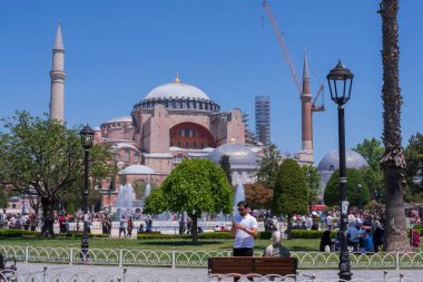 İstanbul 'daki tarihi Ayasofya, Trkiye, turist kalabalığı ve açık mavi gökyüzüyle. Bizans ve Osmanlı mimarisinin ikonik anıtında kubbeler ve minareler yer almaktadır. 19 Mayıs 2025
