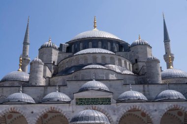 İstanbul 'daki Sultan Ahmed Camii (Mavi Cami). Açık gökyüzünün altında, Osmanlı İslami mimarisini sergileyen kubbelerin ve uzun minarelerin yakın çekimi. Seyahat, kültür ve tarih temaları için mükemmel.