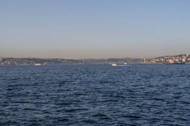 İstanbul, Türkiye 'deki İstanbul Boğazı, berrak mavi suları, çağdaş şehir silueti, köprüleri ve altın saat boyunca gemileriyle, seyahat, denizcilik ve turizm sektörü projeleri için ideal.