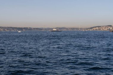 İstanbul, Türkiye 'deki İstanbul Boğazı, berrak mavi suları, çağdaş şehir silueti, köprüleri ve altın saat boyunca gemileriyle, seyahat, denizcilik ve turizm sektörü projeleri için ideal.