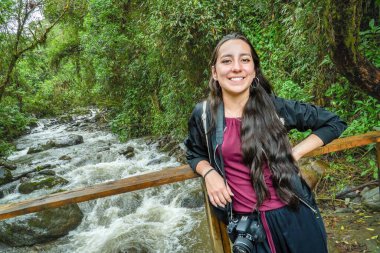 Vahşi doğada seyahat eden İspanyol kadın. Dağda İspanyol bir gezgin. Bir gölün önünde mutlu bir yürüyüşçü.