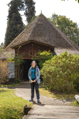 Frutillar, Şili 'deki Alman Koloni Müzesi' nde gülümseyen genç bir İspanyol kaşif. Alman evinin yakınındaki bir turist.