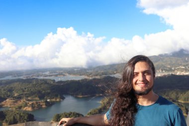 Guatape 'de bir turist. Medellin, Kolombiya. Gökyüzüne karşı büyük gölü olan bir gezginin panoramik görüntüsü.