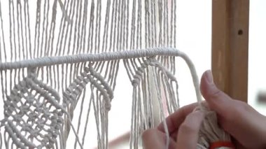 Makrome tekstil sanatı yaratırken zanaatkârların düğüm attığı yakın çekim.