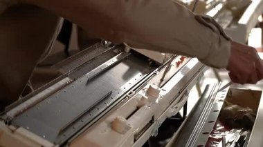 Bir atölyede el örgüsü makinesi kullanan zanaatkar ellerin yakın çekimi..