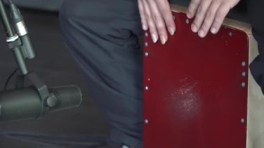 Bir stüdyo oturumu sırasında davul çalan bir müzisyenin sesi kaydeden bir mikrofonla yakın çekimi. Profesyonel ortamdaki perküsyon performansı.