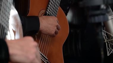 Profesyonel ses kaydı için ayarlanmış mikrofonları olan klasik bir gitar çalan ellerin yakın çekimi.