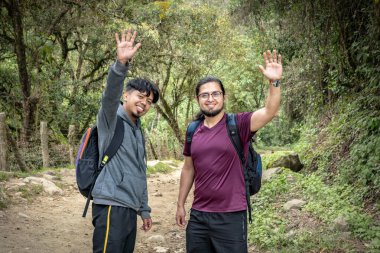 Dağlık bir arazide yürüyen iki Latin adam.