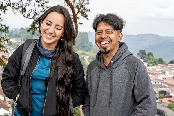 Dağlık bir şehir manzarasının ortasında bir çift gezgin arkadaş..