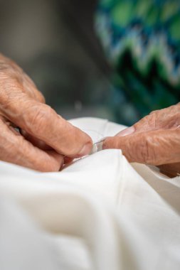 Yaşlı terzi. Eller dikiş, ölçme, kesme ve elle dikme ile çalışıyor. Yaşlı kadın terzi.