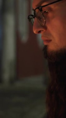 Bir insan gece saatlerinde renkli mumların üzerinde ellerini ısıtarak huzurlu ve samimi bir atmosferi çağrıştırıyor. Kolombiya Mumlar Günü.