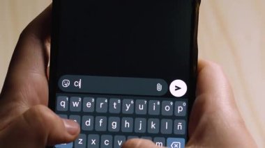 Akıllı telefonu tutan ve mesajlaşma uygulamasında Ci vediamo yazan ellerin yakın çekimi..