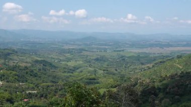 Buenavista Kolombiya adlı küçük bir kasabanın panoramik manzarası, mavi gökyüzünün altındaki vadiler ve dağlarla çevrili yeşil bir yamaçta..