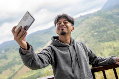 Latin yürüyüşçü dağda selfie çekiyor. Dışarıda selfie çeken bir adam - kamera bakış açısı