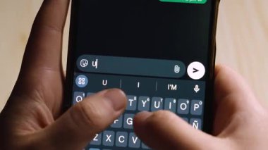 Acil 'i yazarken akıllı telefonu tutan eller!!! Acil ve önemini vurgulayan karanlık mod mesajlaşma uygulamasında.