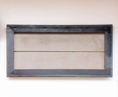 Beyaz arka planı olan beyaz bir duvarda tahta bir çerçeve.