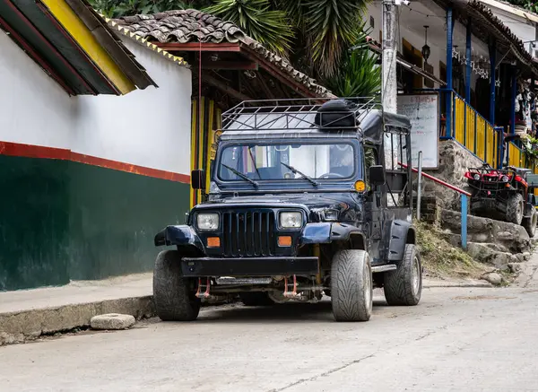 Quindio, Kolombiya 'da kamu Jeep Willys servis aracı. Kahve bölgesinden gelen ikonik turuncu nakliye And Dağları 'ndaki bir sömürge caddesine park edilmiş.