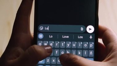 Kendini sevdirmeyi teşvik eden motive edici bir mesaj yazarken akıllı telefonu tutan ellerin yakın çekimi.