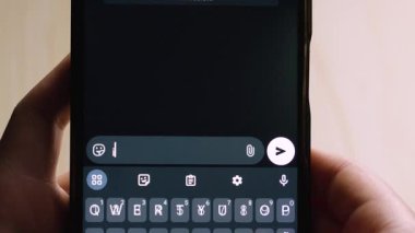 Akıllı telefonu tutan bir elin yakın çekimi, 