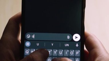 Akıllı telefonu tutan bir elin yakın çekimi, İspanyolca 