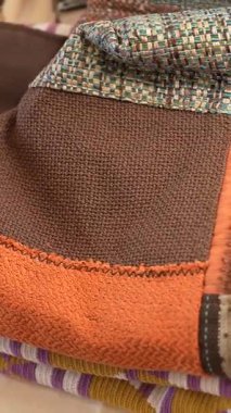 Kahverengi, turuncu ve çok renkli desenli dikişli yama kumaşının detaylı görünümü.