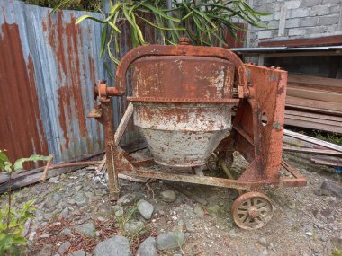 Turuncu demirden yapılmış eski bir beton karıştırıcı dışarıya yerleştirilir. Ya da... İnşaat alanlarında sıklıkla kullanılan çimento karıştırma aracı