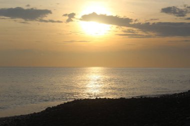 Gün doğumu manzarası Sahilde altın gökyüzüyle