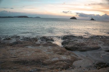 Rocky Shoreline ve Okyanus Manzarası Sakin Deniz ve Adalarla Gün Batımında