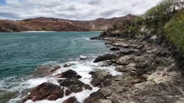 Kıyı şeridinde yükselen insansız hava aracı manzaralı okyanus manzarasını gözler önüne seriyor.