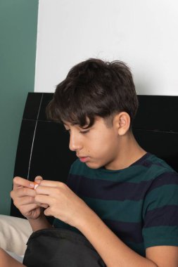 Çocuk sırt çantasının içindekileri yatakta düzenliyor.