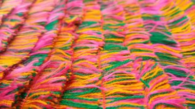 Çok renkli iplikler aşağıya doğru hareket ediyor mikro çekimler, ipliğin yan görünümü, dokuma arkaplanı, nakış için pamuk iplikleri