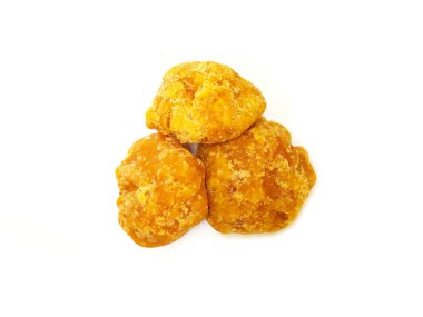 Jaggery veya Gur 'un parçaları ortadaki beyaz arkaplanda izole edilmiş. Organik kahverengi kamış şeker parçası izole edildi