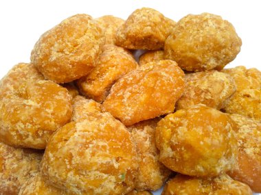 Beyaz arkaplandaki Jaggery veya Gur parçalarını yakın plan çek. Kahverengi organik şeker parçaları.